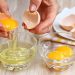 Wanita memisahkan kuning dan putih telur