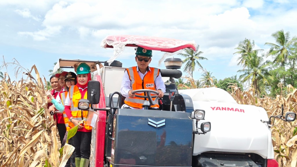 Para petani hadir di Panen Raya Jagung GNTI Pesawaran, dengan Rokhmin Dahuri mengoperasikan combine harvester sebagai simbol modernisasi pertanian.
